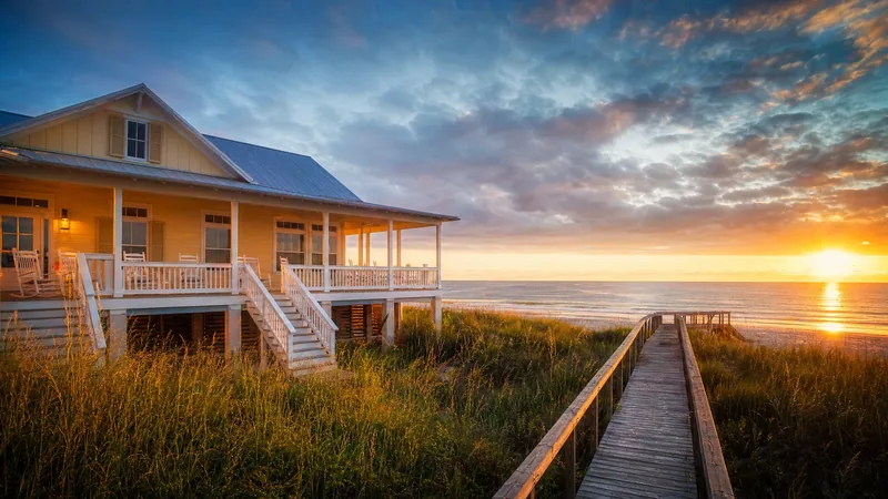 Raised beach cottage with a wraparound porch and a dune walkover at sunset, Mississippi Short-Term Rental Laws